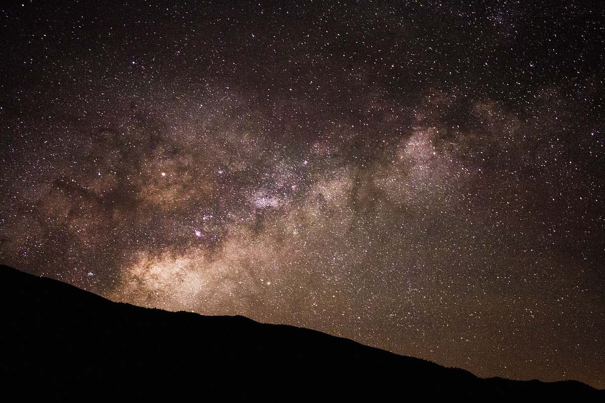 milky way silhouette of hill under starry sky stars